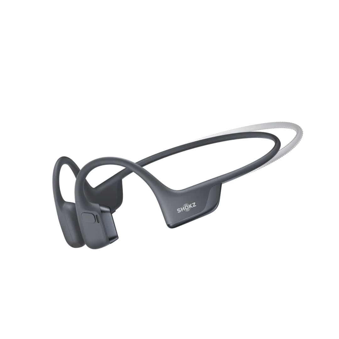Graue Shokz-Knochenschallkopfhörer. Sie haben ein flexibles Band, das um den Hinterkopf geht. Der Markenname ist sichtbar.