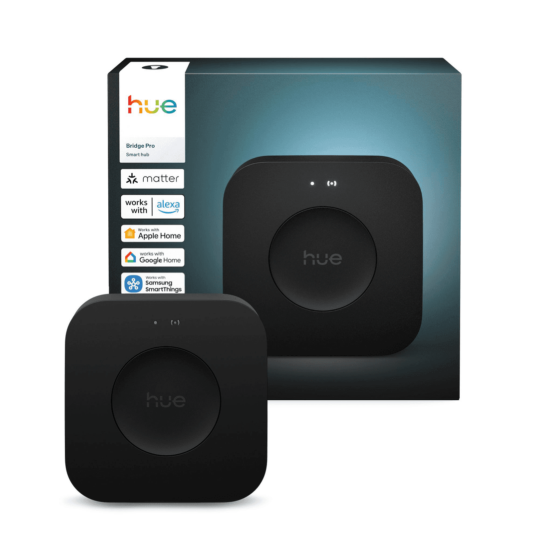 Das Bild zeigt eine schwarze Philips Hue Bridge Pro vor einer Box mit demselben Produkt. Mehrere Logos sind sichtbar.