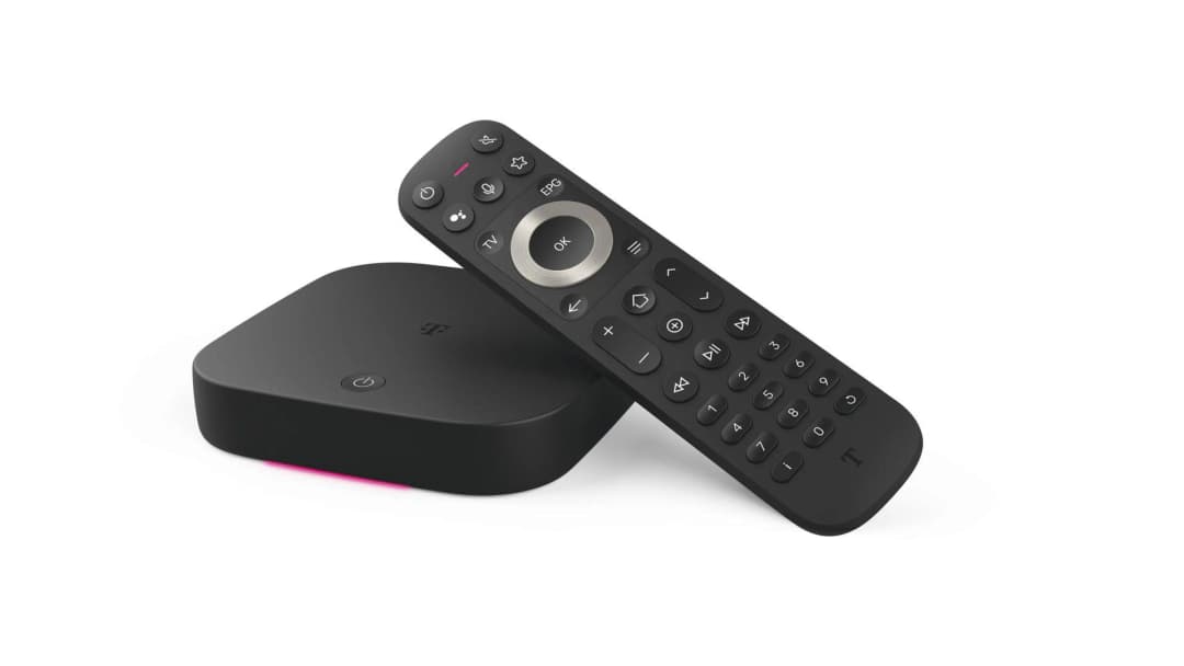Eine schwarze TV-Box und Fernbedienung auf weißem Untergrund. Die Box hat ein T-Logo und ein leuchtendes pinkes Licht.