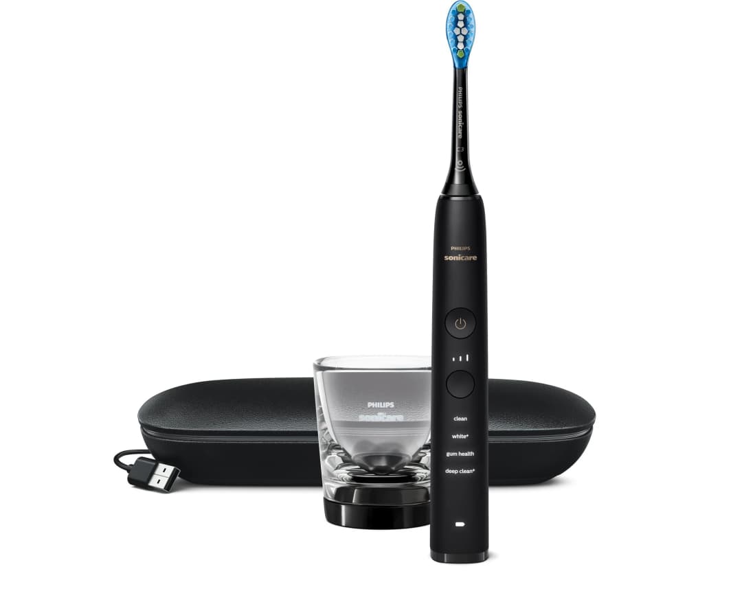 Schwarze Philips Sonicare Zahnbürste mit Zubehör. Enthält eine Reisehülle, ein Ladeglas und ein USB-Kabel.