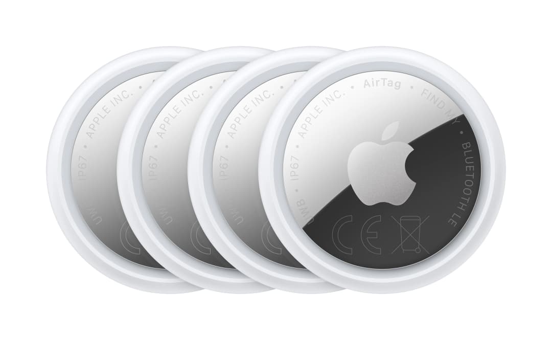 Vier weiße Apple AirTags nebeneinander auf weißem Hintergrund.