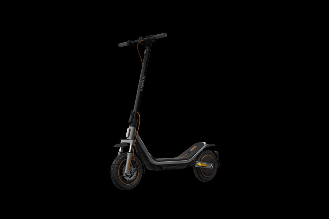 Ein grauer Xiaomi E-Scooter mit orangefarbenen Akzenten steht vor schwarzem Hintergrund.