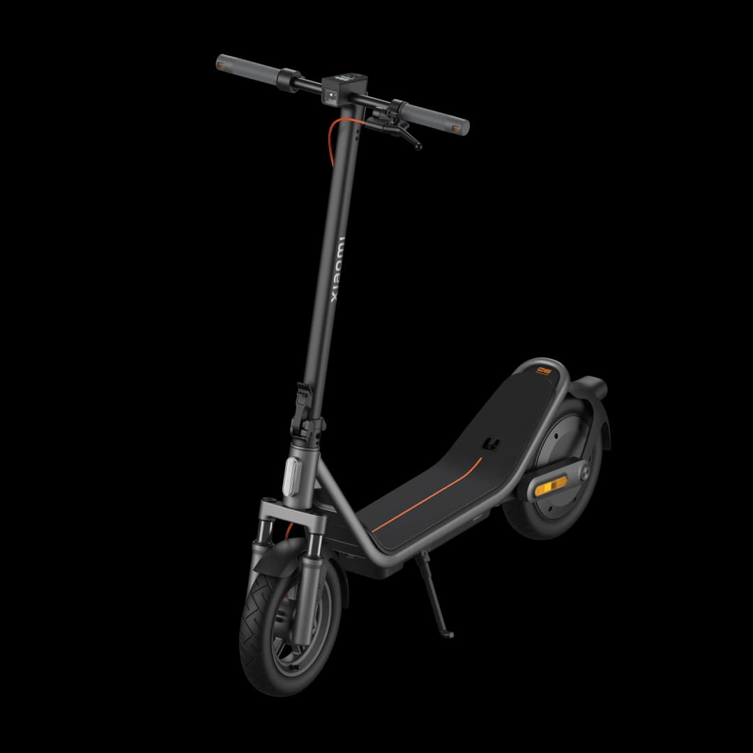 Ein schwarzer E-Scooter mit orangefarbenen Akzenten steht auf schwarzem Hintergrund.